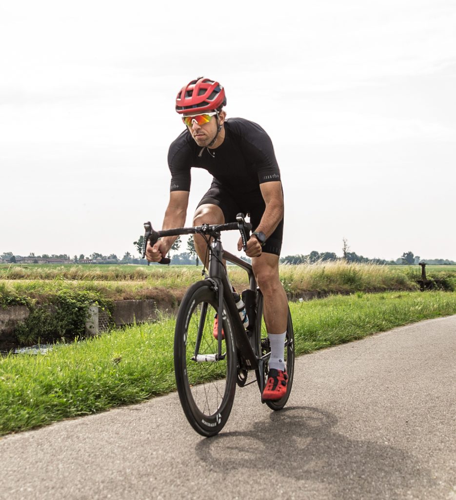 Ciclista durante una sessione di allenamento in riva al naviglio