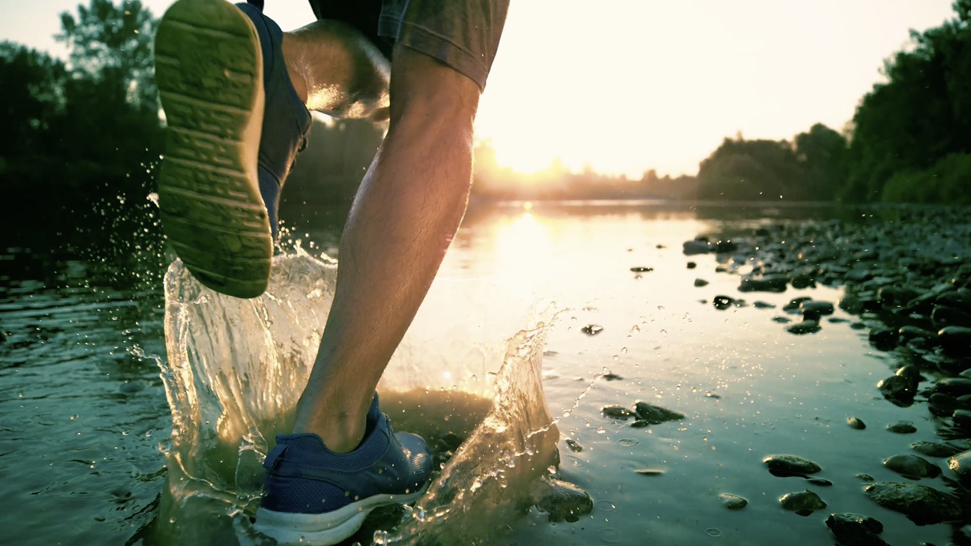 Runner che corre in riva ad un fiume alle prime luci dell'alba