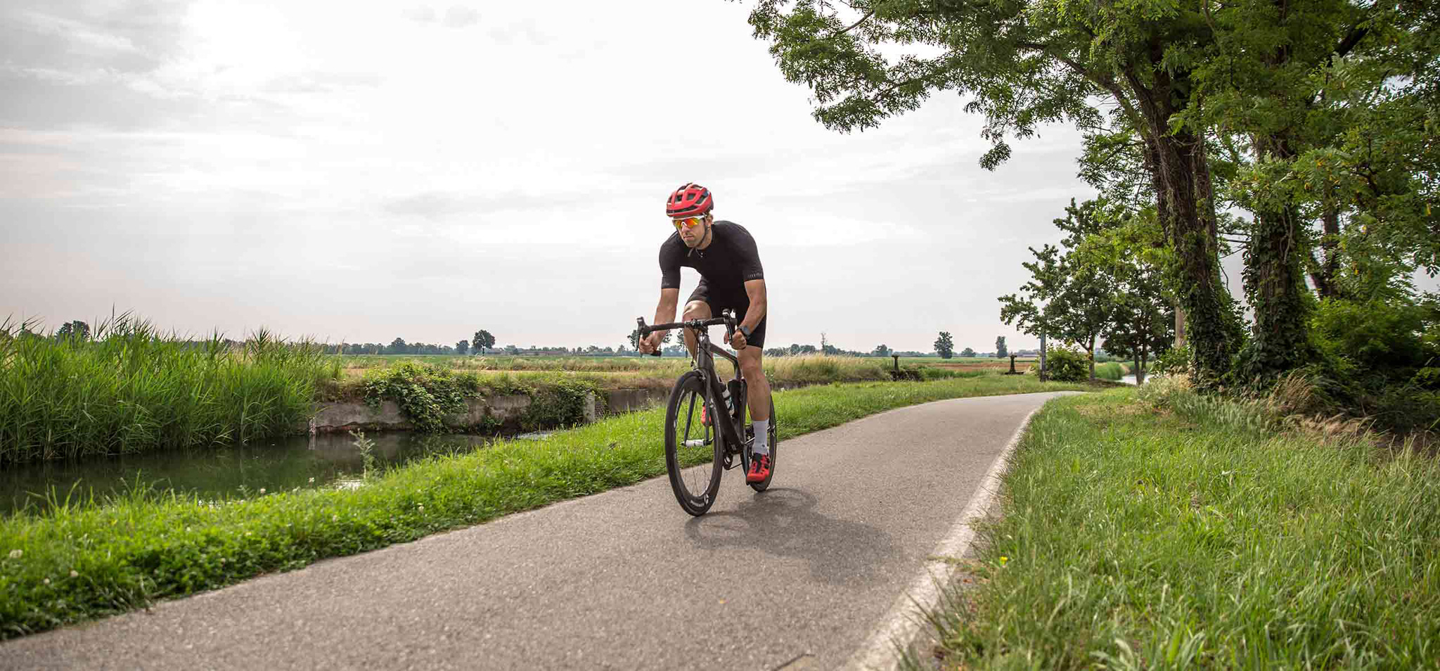 Ciclista che corre lungo il naviglio